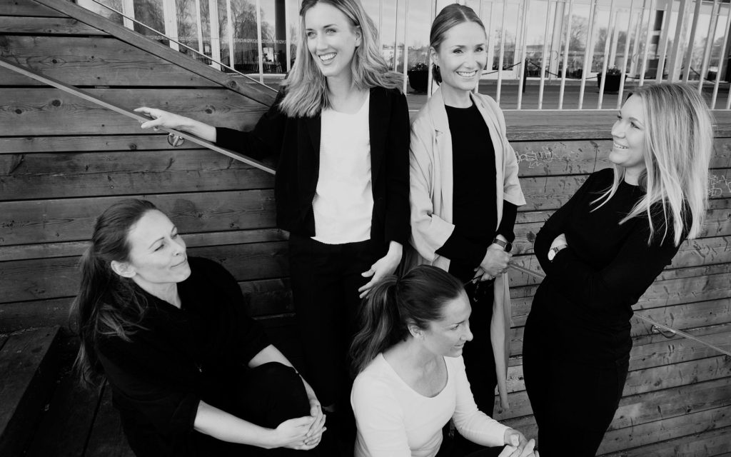 Anställda inredare från Heads and Tails står tillsammans på en brygga i karlstad.