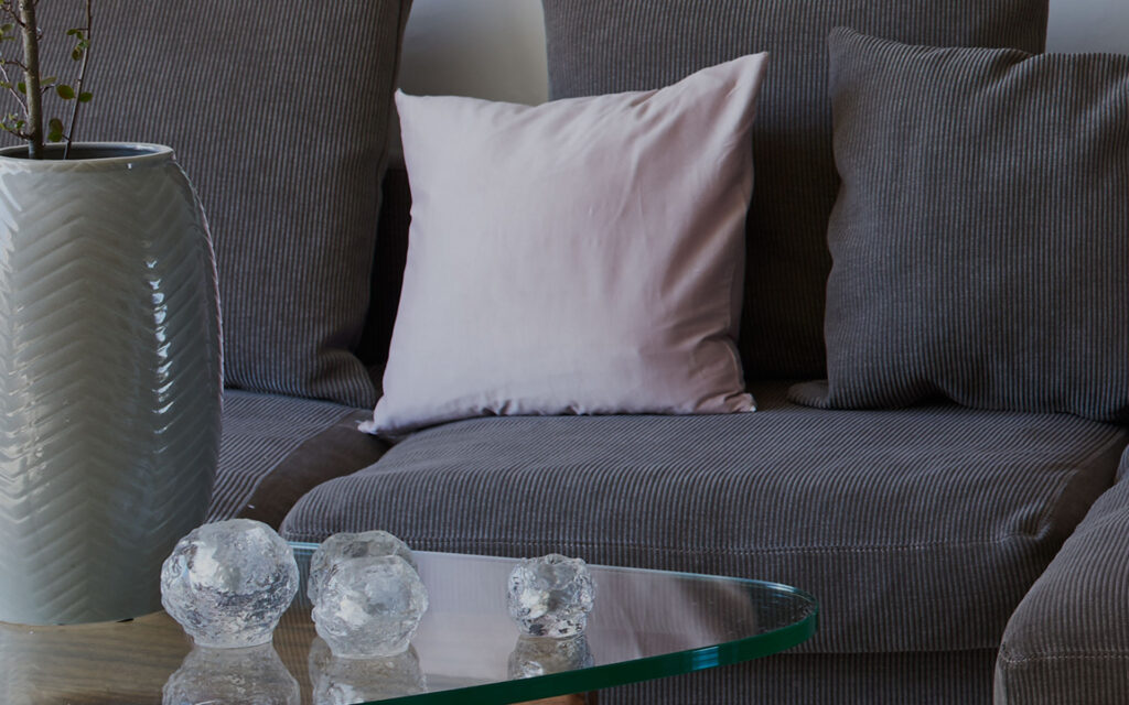 Ljus kudde i kontrast till soffa. En modern inredningsdetalj vid renovering av privat villa.