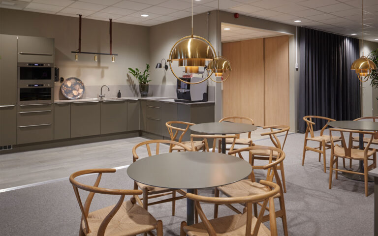 Lunchrum hos Beves - luftig grön köksinredning med dämpad belysning, designmöbler i trä och mässigsdetaljer